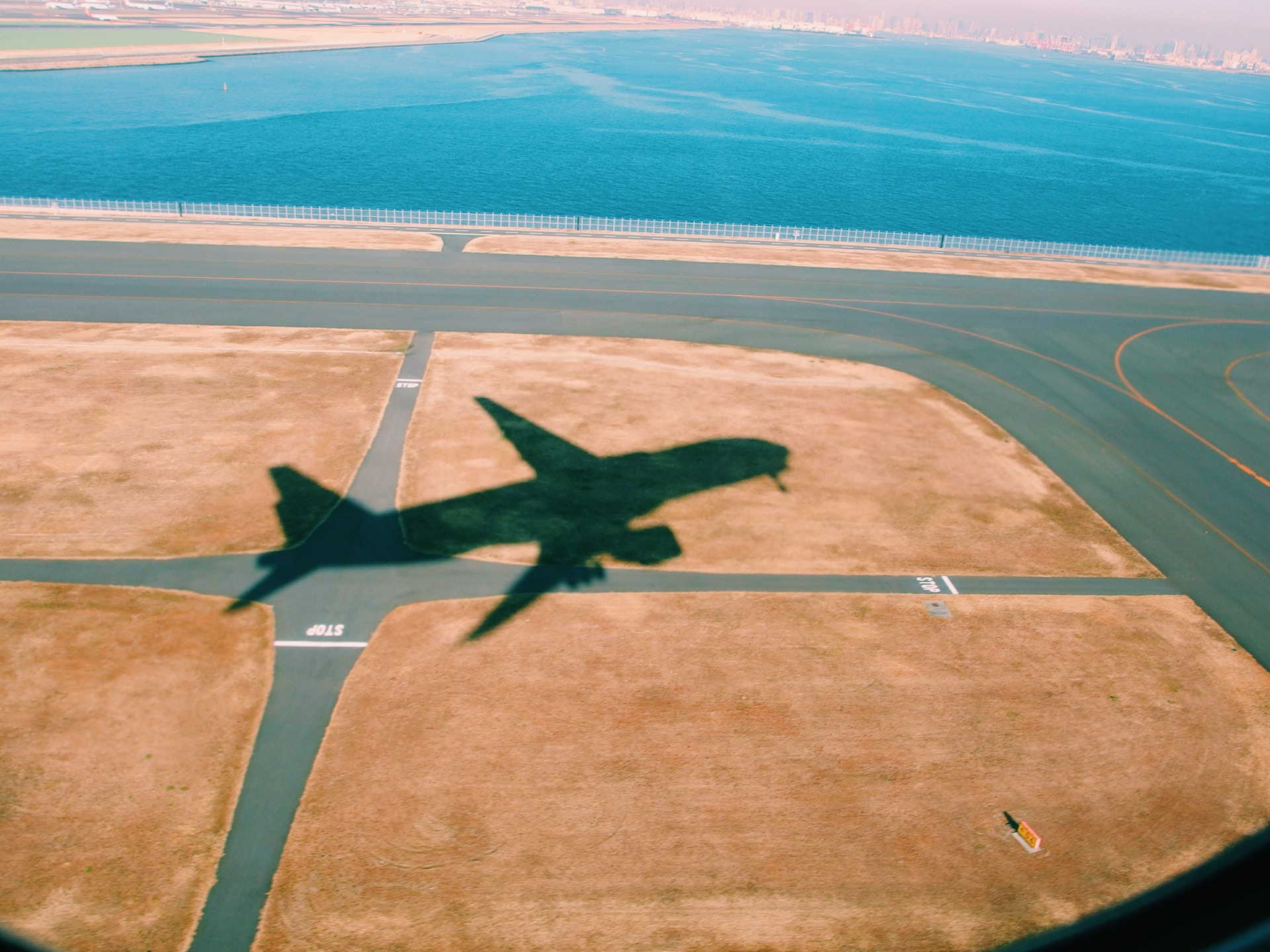 aeroplane shadow flying over airport runway